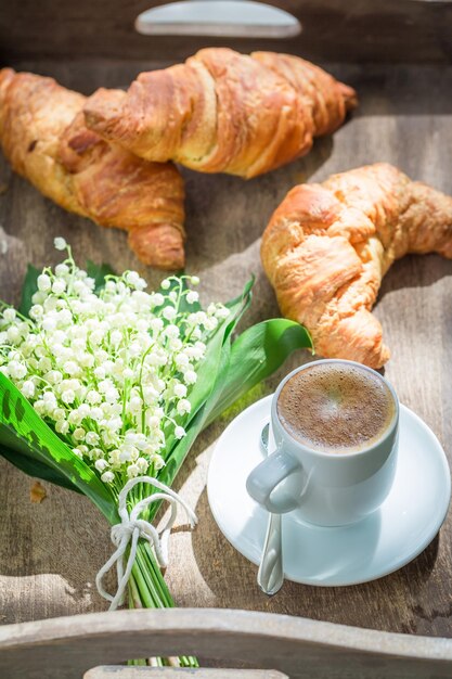 Croissant dulce y café para desayunar en un día soleado