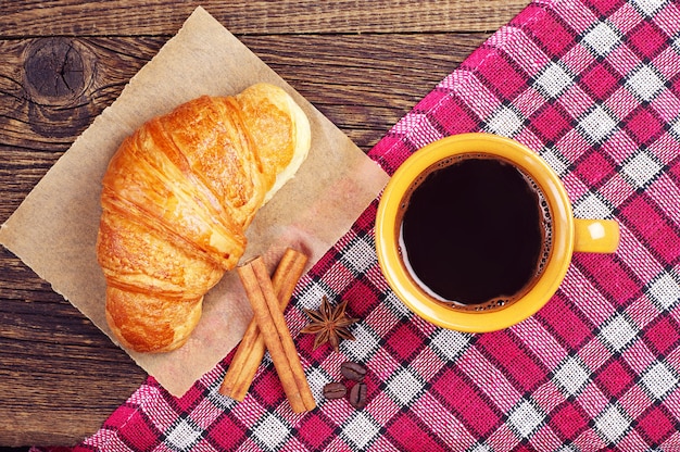 Croissant e café na mesa de madeira