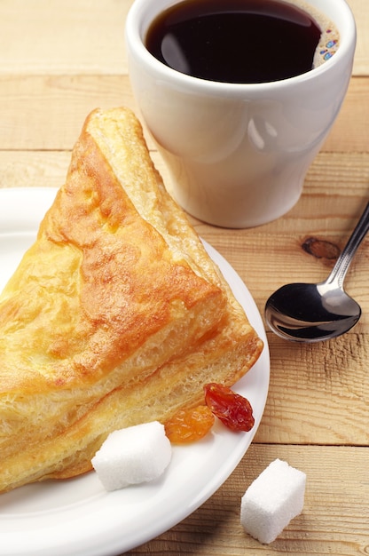 Croissant e café na mesa de madeira