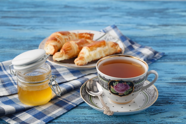 Croissant e chá na caneca. Conceito de pequeno-almoço