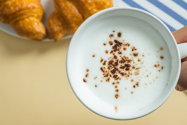 Croissant e leite quente em amarelo