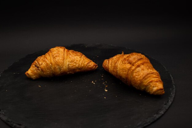 Croissant em fundo preto tiro de comida detalhada