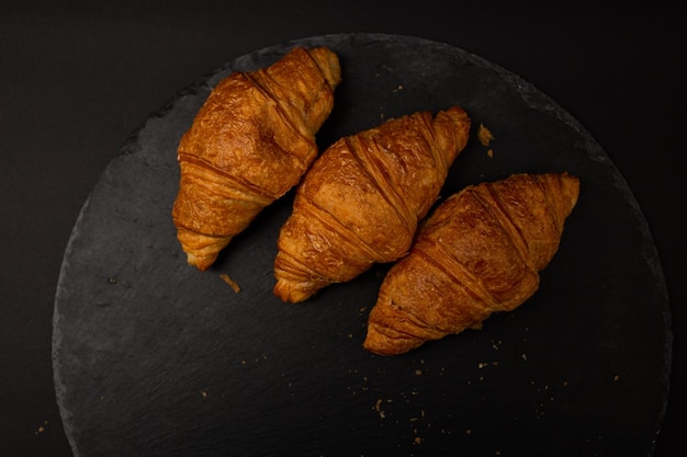 Croissant em fundo preto tiro de comida detalhada