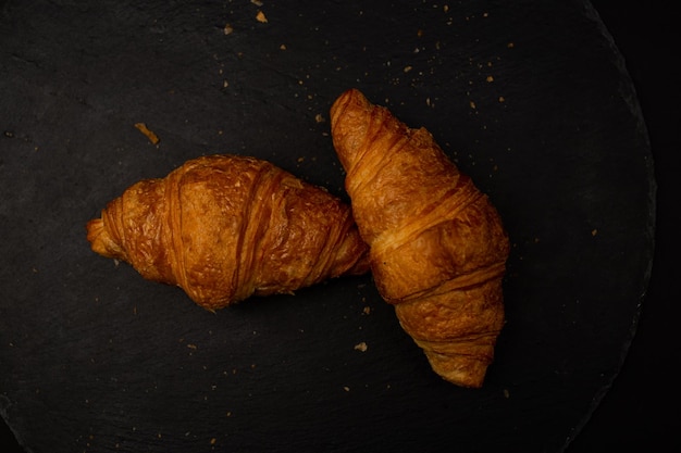 Croissant em fundo preto tiro de comida detalhada