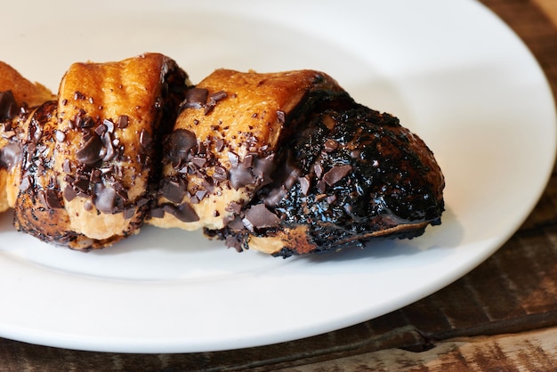 Croissant francês de chocolate em um prato branco. rolos de massa folhada caseiros