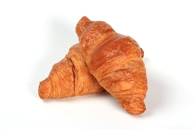 Croissant francés fresco sobre un fondo blanco.