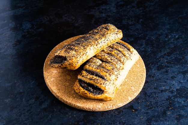 Croissant francés recién respaldado brillante en los rayos del sol de la mañana cocina de fondo oscuro