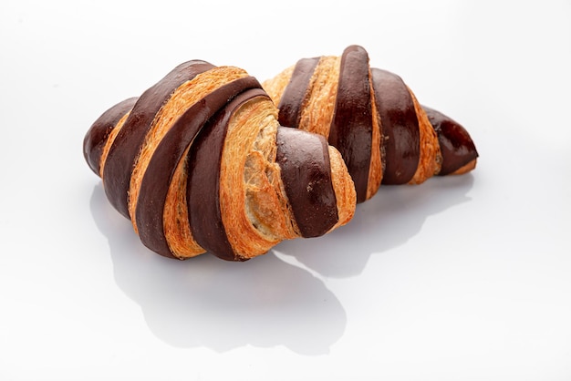 Croissant fresco con chocolate sobre un fondo blanco.