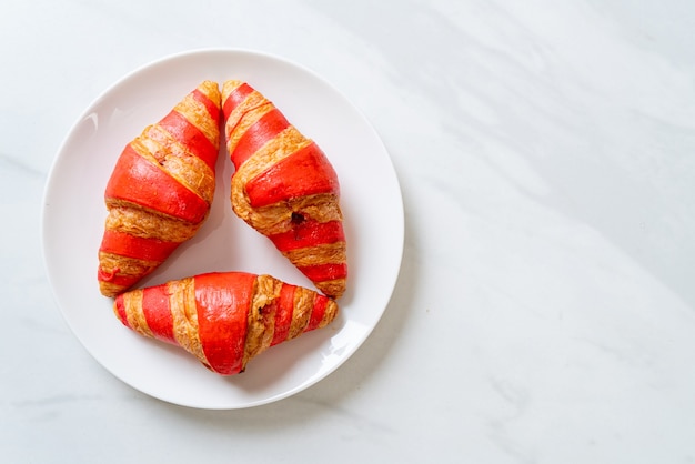 Croissant fresco com molho de geleia de morango no prato