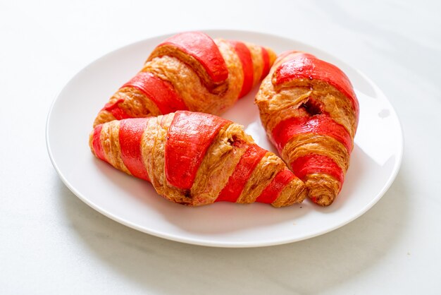 croissant fresco com molho de geleia de morango no prato