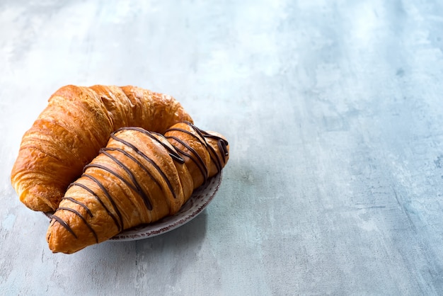 Croissant fresco decorado com molho de chocolate isolado