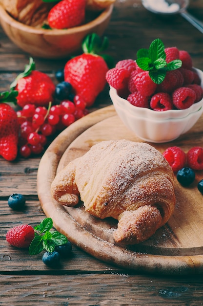 Croissant fresco con mezcla de bayas, enfoque selectivo