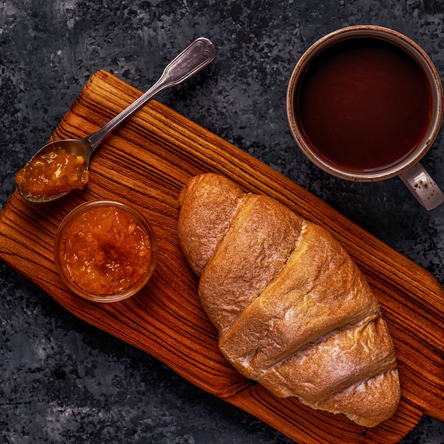 Croissant fresco na mesa escura.