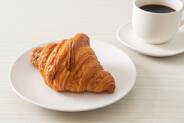 Croissant fresco en la placa blanca.