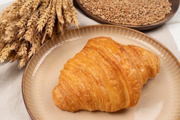 Croissant fresco en una placa de color beige servido mesa con croissant para el desayuno Croissant de panadería fresca