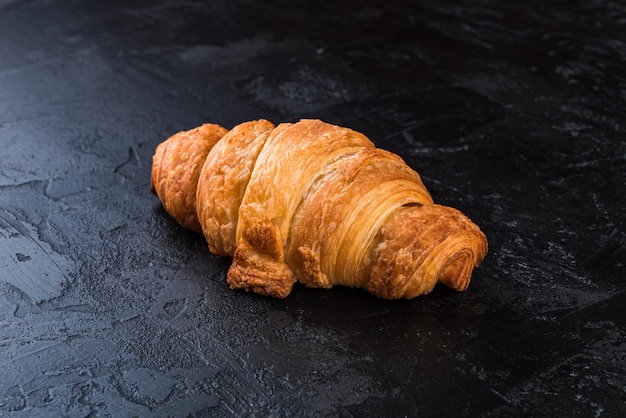 Croissant fresco sobre un fondo de pizarra negra Copiar espacio