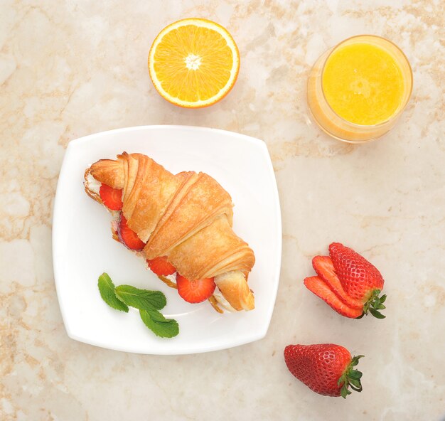 Croissant gefüllt mit Erdbeeren und Sahne