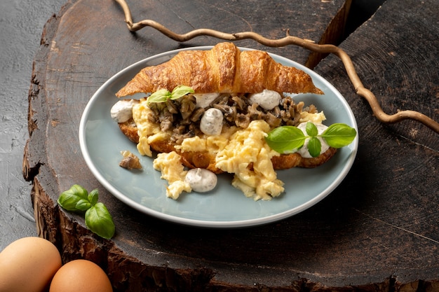 Croissant de huevos revueltos con aderezo de trufa y champiñones.