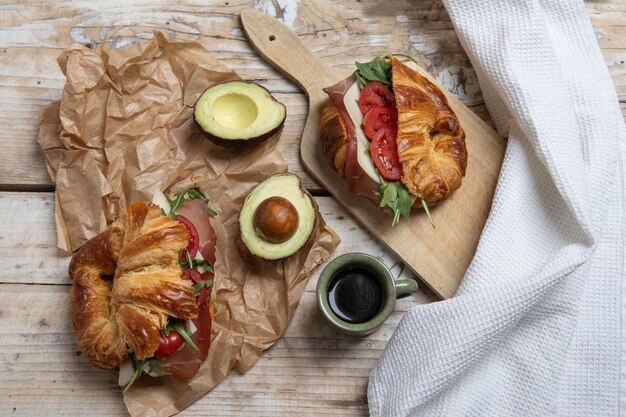 Croissant con jamón, queso, ensalada y tomates para el desayuno