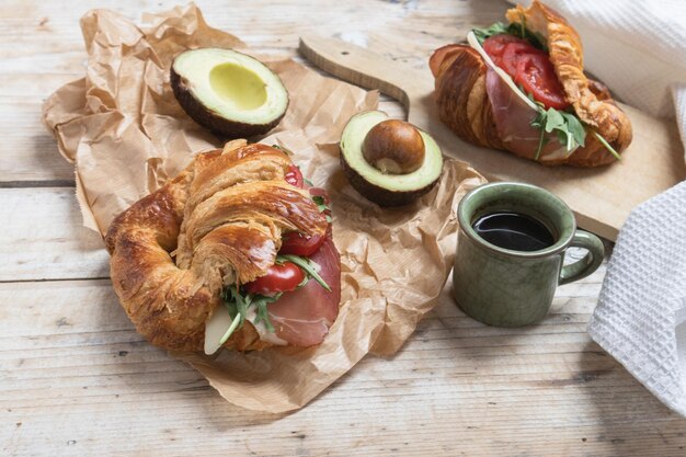 Croissant con jamón, queso, ensalada y tomates para el desayuno