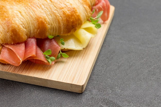 Foto croissant con jamón y queso y verduras. copie el espacio.