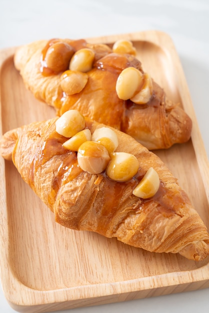 Croissant con macadamia y caramelo en placa de madera