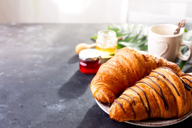 Croissant, mermelada, frutos del bosque y café