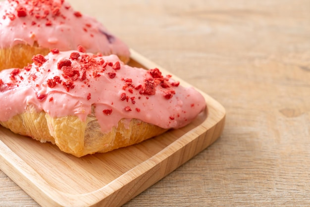 Croissant mit Erdbeer-Schokoladensauce auf Holzteller