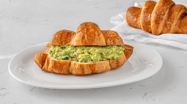 Croissant mit Guacamole auf dem Servierteller