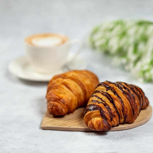 Croissant mit Kaffee auf weißem Tisch Französisches Frühstück