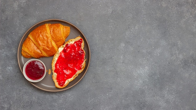 Croissant mit Preiselbeermarmelade und Butter