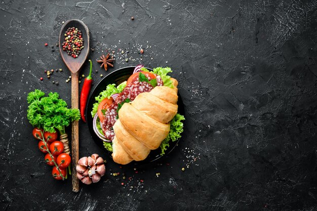 Croissant mit Salami, Tomaten und Zwiebeln Frühstück Draufsicht Freier Platz für Ihren Text