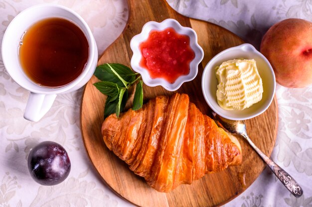 Croissant mit Tee und Marmelade zum Frühstück