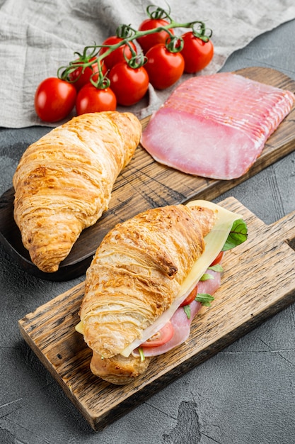 Croissant ou sanduíche fresco com salada, presunto, jamon e presunto definido, em fundo de pedra cinza