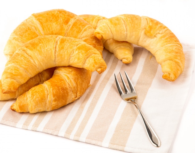 Croissant panes en un paño en un blanco