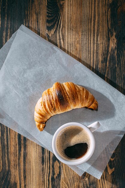 Croissant quente e fresco do conceito do café da manhã e uma xícara de café