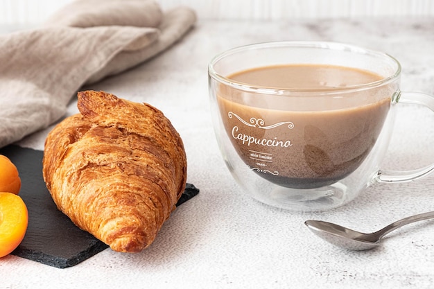 Croissant recién hecho, servido con albaricoques y café. Concepto de desayuno francés, fondo gris