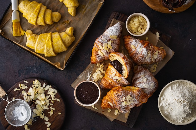 Croissant recién horneado con hojuelas de almendras y azúcar glas vista superior