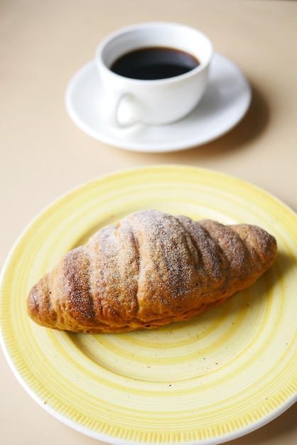 Croissant recién horneado en placa con espacio de copia