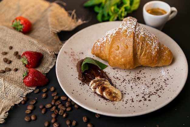 Croissant recién horneado en plato blanco