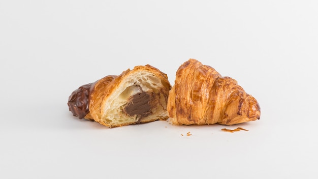 Croissant con relleno de chocolate aislado sobre fondo blanco.