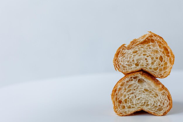 Croissant en rodajas sobre un fondo blanco a la derecha con espacio para texto Textura croissant