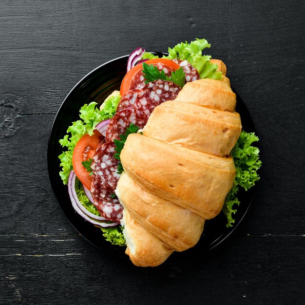 Croissant con salami, tomates y cebollas Desayuno Vista superior Espacio libre para su texto