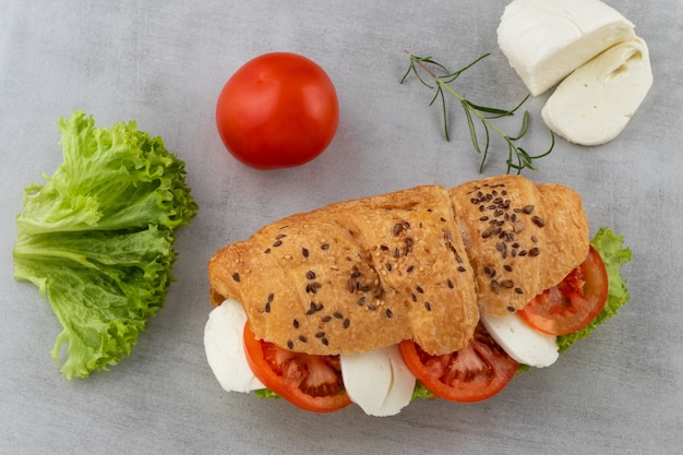 Croissant-Sandwich mit Salat-Mozzarella und Tomate. Gesunder Snack. Draufsicht.