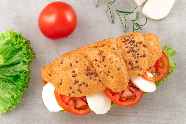 Croissant-Sandwich mit Salat-Mozzarella und Tomate. Gesunder Snack.