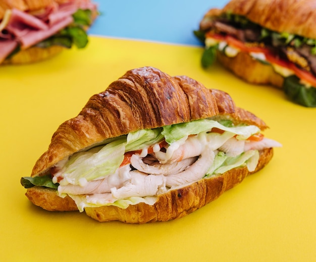 Croissant-Sandwich-Schinken auf Gelb mit blauem Hintergrund