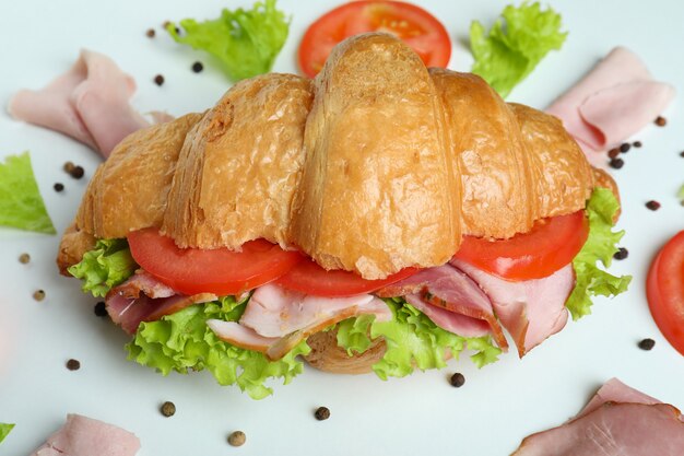 Croissant-Sandwich und Zutaten auf Weiß, Nahaufnahme