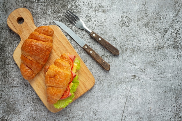 Croissant-Sandwiches auf dunkler Holzoberfläche