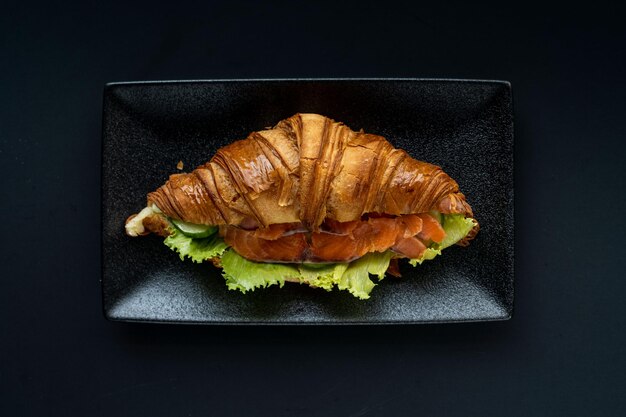 Foto croissant y una taza de té en un enfoque selectivo de fondo neutral