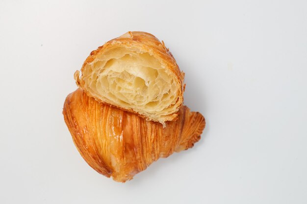 Croissant tradicional recién horneado cortado en dos partes